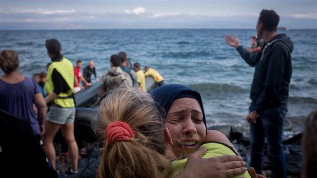 Refugees, primarily from Syria, Iraq and Afghanistan are helped by volunteers as they disembark boats near Scala, on the island of Lesbos, Greece. (UNICEF)