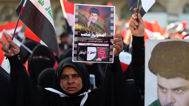 A supporter of Iraqi Shia cleric Moqtada al-Sadr holds the national flag during a demonstration in Baghdad’s Tahrir Square, July 22, 2016. (Photo by AFP)
