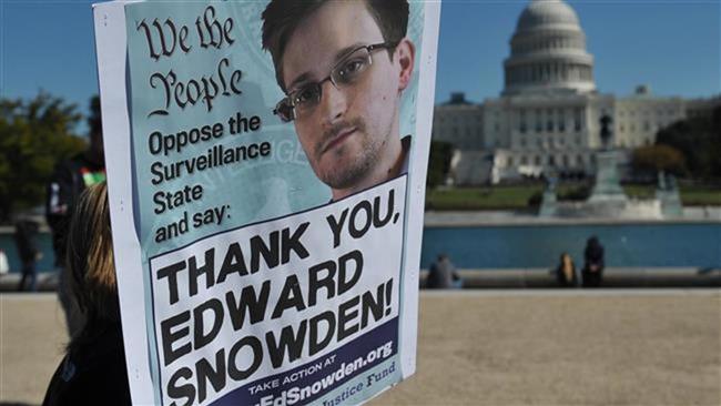 In this October 26, 2013 photo, demonstrators hold placards supporting former US intelligence analyst Edward Snowden during a protest against government surveillance in Washington, DC. (AFP)