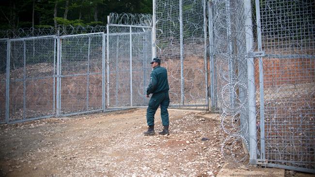 A Bulgarian border guard stands next to a newly built barbed wire fence at the border between Bulgaria and Turkey near the Bulgarian town of Malko Tarnovo on May 22, 2016. (AFP)
