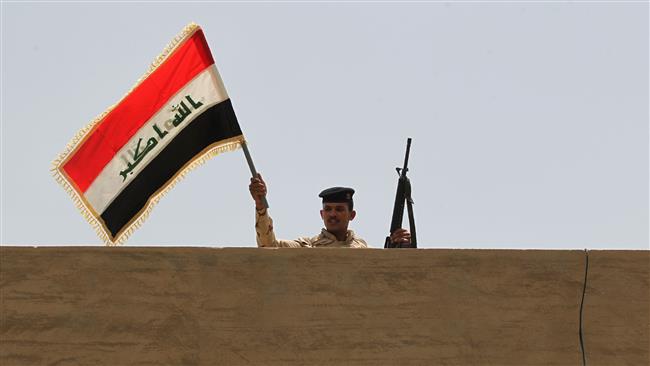 An Iraqi soldier waves the Iraqi national flag above a building in Saqlawiyah, northwest of Fallujah, June 8, 2016. (Photo by AFP)
