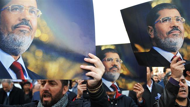 File photo shows supporters of the Muslim Brotherhood movement carrying images of former president Mohamed Morsi during a rally in Cairo.