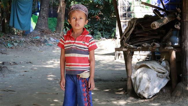 A Muslim boy stands in front of a house in Maungdaw town located in Myanmar