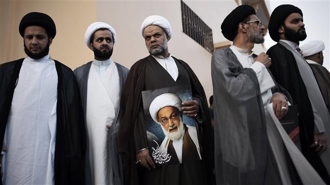 Bahraini Shia clergymen attend a protest against the revocation of the citizenship of top cleric Sheikh Isa Qassim (portrait), near Qassim