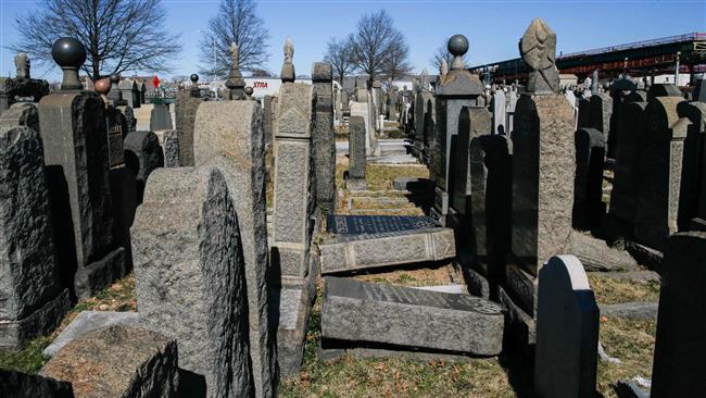 Toppled headstones remain on the ground at Washington Cemetery in the New York borough of Brooklyn on March 5, 2017. (Photo by AFP)
