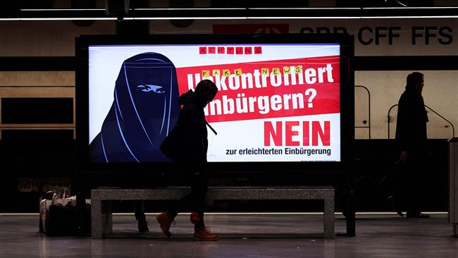 An electoral poster of the Swiss far-right party reading “Uncontrolled Naturalization? No” in German with the illustration of a woman wearing a burka is seen at a train station in Zurich, Switzerland, on February 7, 2017. (Photo by AFP)

