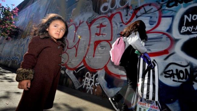 Three year old Saria Amaya (L) waits with her mother after receiving shoes and school supplies during a charity event to help more than 4,000 underprivileged children at the Fred Jordan Mission in the Skid Row area of Los Angeles. (Photo by AFP)
