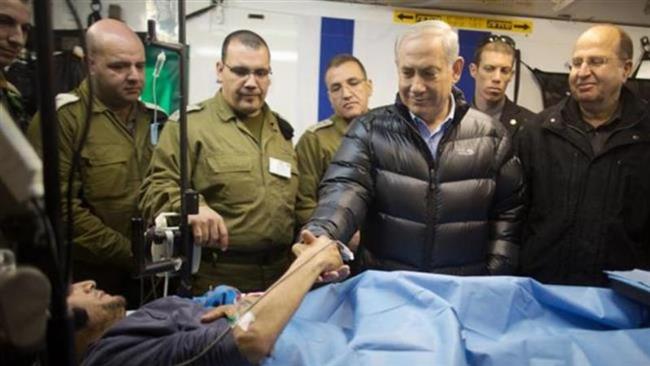 The file photo shows Israeli Prime Minister Benjamin Netanyahu shaking hands with a wounded Takfiri militant at an Israeli field hospital in Syria’s occupied Golan Heights.