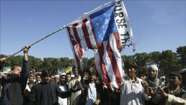 The undated photo shows Afghan demonstrators burning an American flag during a protest in Herat province.
