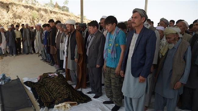 Afghan Shia mourners and relatives pray in front of the coffin of one of 26 victims killed in a car bombing in Kabul on July 25, 2017. (Photo by AFP)
