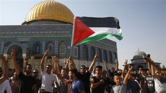 Palestinians wave a national flag near the Dome of the Rock shrine (Qubbat al-Sakhrah) in the al-Aqsa Mosque compound in Jerusalem al-Quds