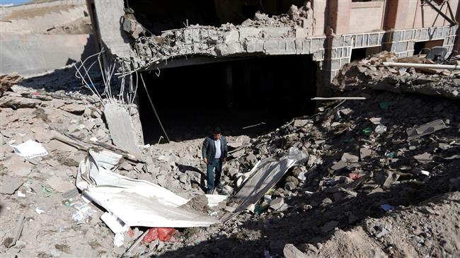 A picture taken on February 5, 2018 shows a man standing inside a crater at the Yemeni Criminal Investigations Unit in the capital, Sana’a, a day after it was hit by a Saudi-led airstrike. (Photo by AFP)

