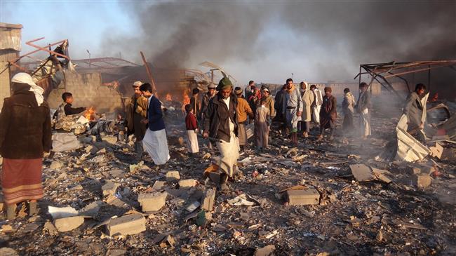 Smoke rises as Yemenis inspect the damage at the site of Saudi airstrikes in the northwestern city of Sa