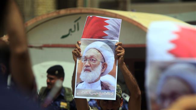 An Iraqi man holds a picture of top Bahraini Shia cleric Isa Qassim during a demonstration in front of the Bahraini consulate in Najaf, May 24, 2017. (Photo by AP)
