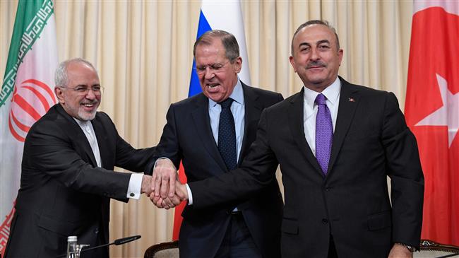 Russian Foreign Minister Sergei Lavrov (C), his Iranian counterpart Mohammad Javad Zarif (L) and Turkish Foreign Minister Mevlut Cavusoglu shake hands at the end of a joint press conference following their talks in Moscow on April 28, 2018. (Photo by AFP)
