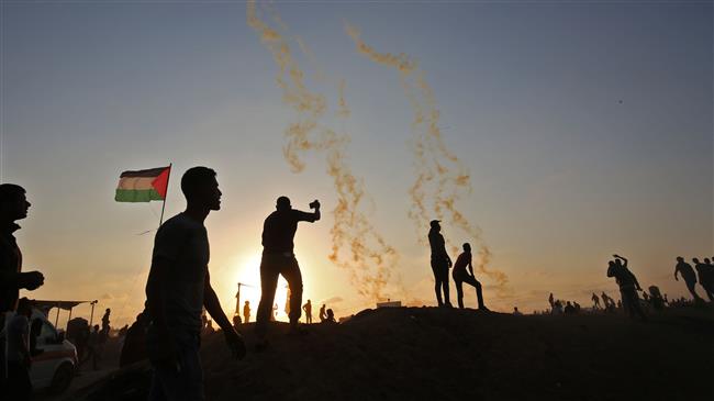Palestinians protest as tear gas fumes erupt in the southern Gaza Strip on May 15, 2018. (Photo by AFP)
