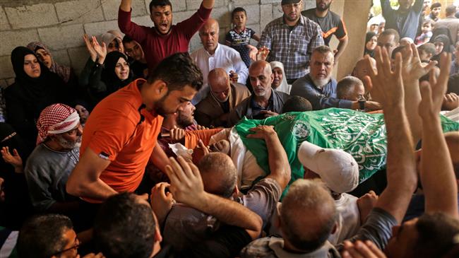 Palestinian mourners carry the body of 51-year-old Nasser Ghorab during his funeral in al-Nusirat refugee camp in the central Gaza strip on May 16, 2018. (Photo by AFP)
