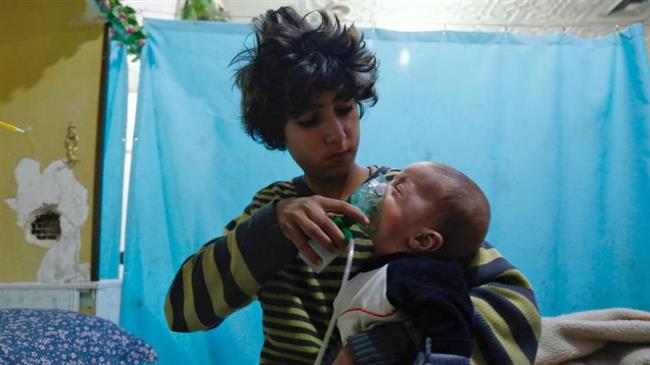 A Syrian boy holds an oxygen mask over the face of an infant at a make-shift hospital following an alleged gas attack in Douma in the Eastern Ghouta outskirts of the Syrian capital, Damascus, on January 22, 2018. (Photo by AFP)