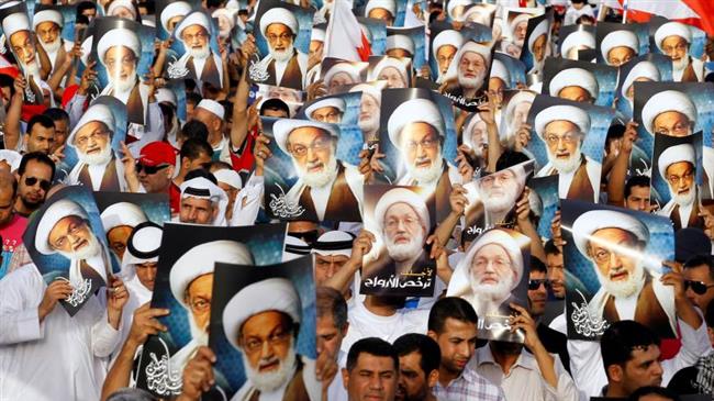 Anti-government protesters hold posters of Shia cleric Sheikh Isa Qassim in Budaiya, Bahrain, in 2013. (Photo by Reuters)
