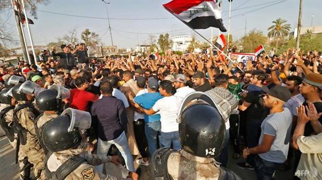 Iraqis shout slogans and wave national flags during a demonstration outside the local government headquarters in the southern city of Basra on Jul 13, 2018. (Photo by AFP)

