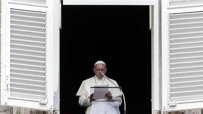 Pope Francis reads to pilgrims during The Angelus Prayer from the window of his studio overlooking St. Peter