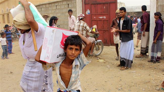 This picture taken on July 17, 2018 shows displaced Yemenis from Hudaydah receiving food aid from a Japanese NGO in the northern district of Abs, Hajjah province, Yemen. (Photo by AFP)
