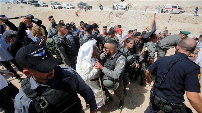 A Palestinian man scuffles with Israeli troops as they protest against Israel