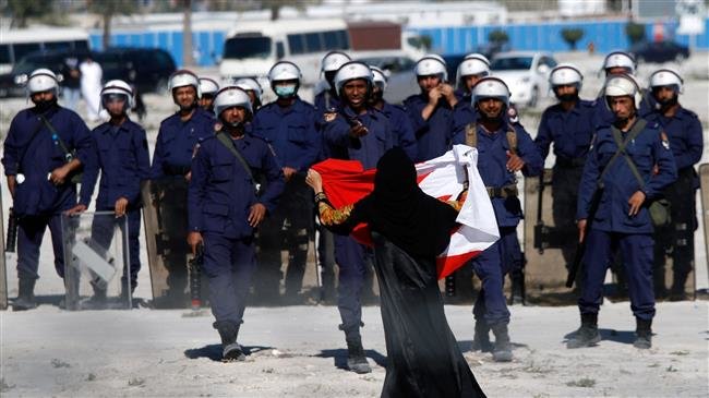 In this file picture, an anti-regime protester gestures in front of police as demonstrators re-occupy Pearl roundabout in Manama, Bahrain. (Photo by Getty Images)

