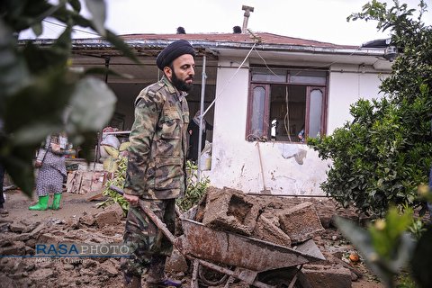 A young clergyman in flood-hit Province of Mazandaran, voluntarily helps people to rebuild their houses