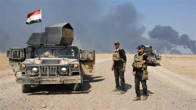 Iraqi security forces gather on the outskirt of Qayyarah, Iraq,