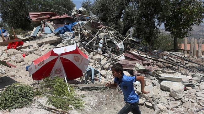 A Palestinian boy walks past a pile of rubble after Israeli military forces demolished a building in the village of Sebastia, near the occupied West Bank city of Nablus, August 9, 2016. (Photo by AFP)