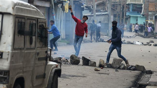 A protester throws a stone toward Indian forces during clashes in Srinagar, Kashmi