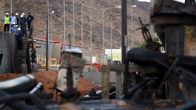 Foreign workers inspect the damage at an electricity company