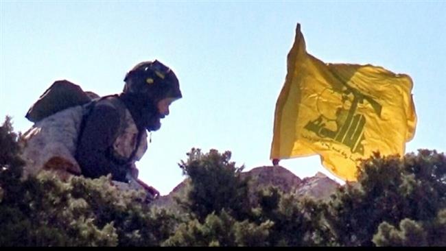 This picture released by the Hezbollah press office on May 13, 2015 shows a Hezbollah fighter erecting the flag of the party on the Tallet Moussa area on the Syrian side of the Qalamun hills close to the Lebanese borders.