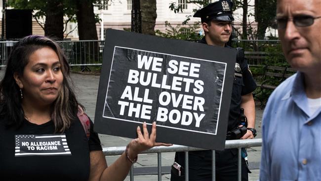 A Black Lives Matter activist holds up a sign during a protest against police brutality at City Hall Park, August 1, 2016 in New York City.

