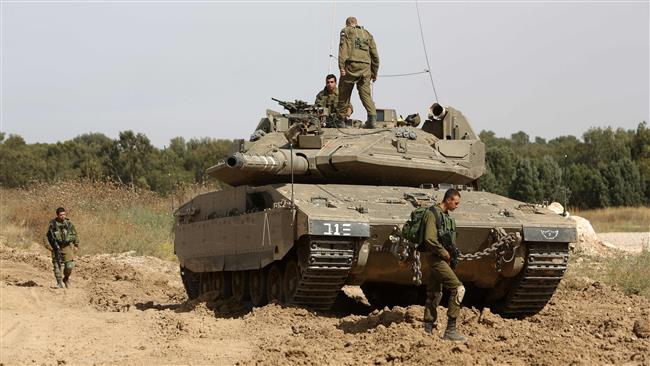 Israeli soldiers stand guard with their tank along the border between Israel and the Gaza Strip, May 4, 2016. (AFP)