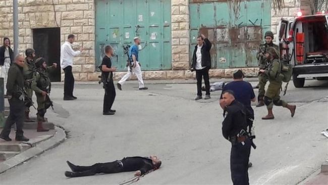 The photo shows the body of Abdel-Fattah al-Sharif lying on the ground. The Palestinian was fatally shot by an Israeli soldier in the West Bank city of al-Khalil, aka Hebron, March 24, 2016. (Photo by Ma’an)
