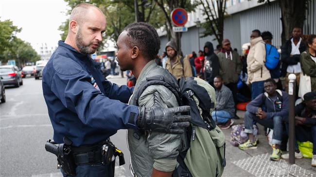 A policeman stops a refugee trying to go back to a makeshift camp on September 6, 2016 in Paris.