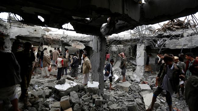 People gather at a building destroyed by Saudi airstrikes in the northwestern Yemeni city of Amran on September 8, 2016. (Reuters)