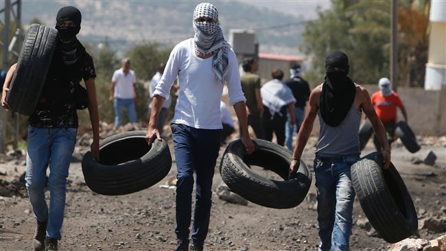 Palestinian protesters carry tires to burn during clashes with Israeli forces in the village of Kfar Qaddum, near Nablus in the occupied West Bank, September 9, 2016. (AFP)