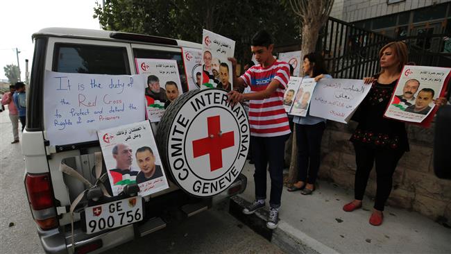 Palestinians cover a Red Cross vehicle with posters as they demonstrate in front of the Red Cross headquarters in the West Bank city of Ramallah in support of prisoners on hunger strike in Israeli jails on August 24, 2016. (AFP)
