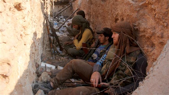This picture taken on August 6, 2016 shows members of the Jabhat Fateh al-Sham terrorist group sitting in a trench in the northern Syrian city of Aleppo. ©AFP
