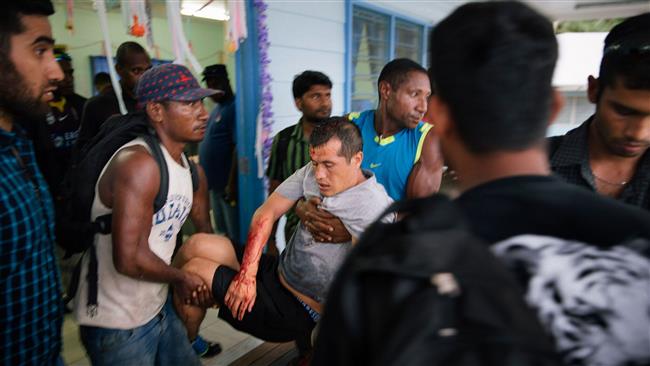 An injured Afghan refugee (C) from an Australian detention facility in Manus Island being carried by two men after he was allegedly attacked by a group of Papua New Guinean men while out on a day release. (AFP photo)