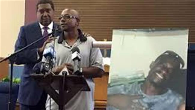Robert Mann speaks next to a picture of Joseph, his brother, who was killed by police officer on July 11, 2016. (Photo from social media)
