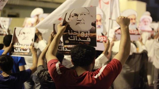 Protesters holding images of leading Shi’a cleric Ayatollah Isa Qasim take part in an anti-regime protest in the village of Diraz, west of Manama, on September 28, 2016