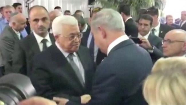 A still taken from a handout video shows Palestinian President Mahmoud Abbas shaking hands with Israel