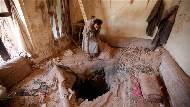 A man inspects the damage in a house after a Saudi air strike in the Old City of Sana