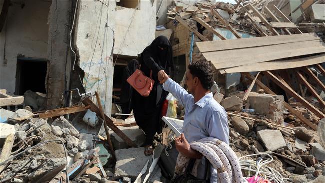 The picture, taken on September 22, 2016, shows Yemenis making their way through the rubble of buildings destroyed in Saudi airstrikes in the Yemeni port city of Hudaydah.