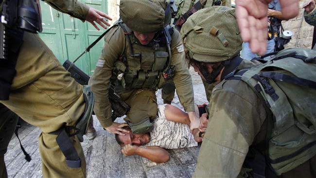 Israeli troops restrain a Palestinian man as troops try to abduct him in the flashpoint city of Hebron (al-Khalil), in the occupied West Bank, on September 20,2016. (Photo by AFP)
