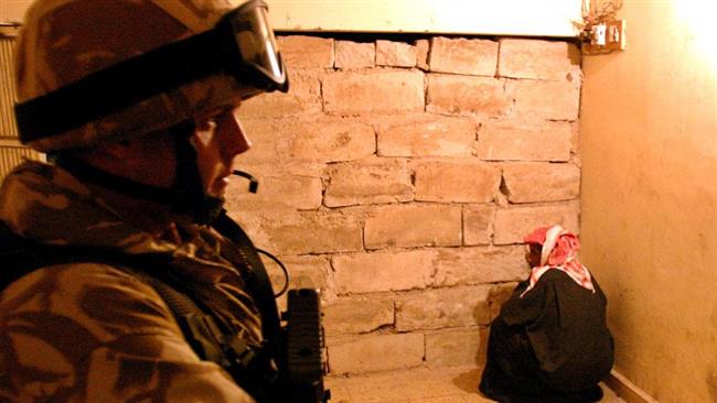 A file photo showing a British soldier guarding an Iraqi detainee in the port city of Basra, in 2005.